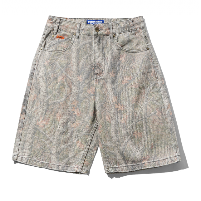 A pair of men's denim shorts featuring a muted, washed camouflage pattern with shades of gray, beige, and soft pink. The shorts have a blue 'BORN TO BE' label on the waistband and a small orange brand tag on the front pocket.